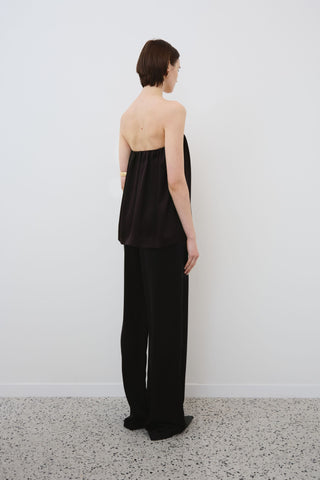 Back view of HERTH Gala off-shoulder silk top and Joy silk trousers in black — sustainable organic silk womenswear made in Italy at Assoluto boutique.