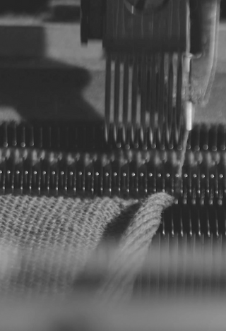 Detail of Fedeli knitwear craftsmanship on Italian textile machine, mobile format.