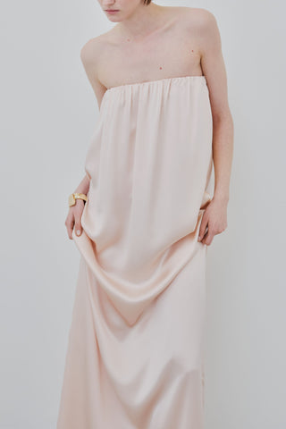 HERTH Erin off-shoulder silk maxi dress in Whisper Pink, crafted in Italy from GOTS-certified organic silk. Available at ASSOLUTO boutique.