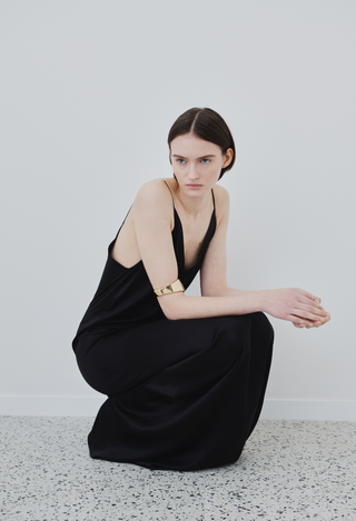 Model wearing HERTH black organic silk slip dress, mobile format — sustainable Italian luxury fashion.