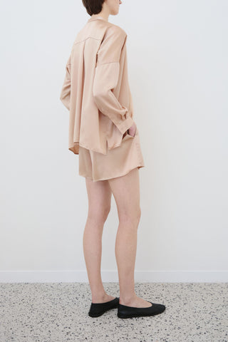 Side view of HERTH Tess silk shirt and Hani silk shorts in sand — sustainable womenswear crafted in Italy curated at Assoluto Boutique.