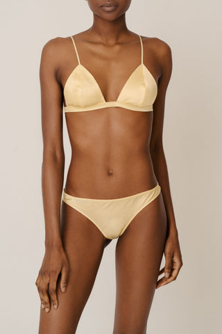 Front view of HERTH Ivy triangle bra and Zoe low-rise panty in Yellow Butter organic silk — sustainable lingerie crafted in Italy, available at ASSOLUTO boutique.