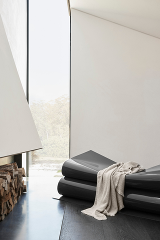 Modern interior with Society Limonta throw blanket draped over designer bench — contemporary Italian home textiles at Assoluto Studio.