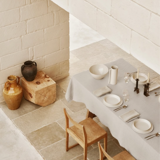 Society Limonta linen tablecloth in a minimal table setting with neutral ceramics and wooden chairs.