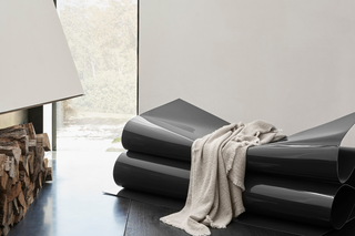 Society Limonta neutral throw blanket draped over modern designer bench — Italian home textiles collection at Assoluto Studio.