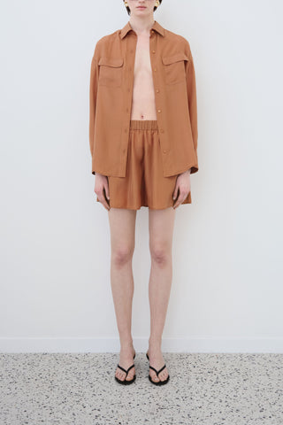 Front view of HERTH Tate shirt and Hani shorts in Rust Habotai silk — elegant sustainable womenswear set crafted in Italy, available at ASSOLUTO boutique.