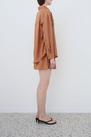 Side view of HERTH Tate shirt and Hani shorts in Rust Habotai silk — minimalist sustainable womenswear set made in Italy, available at ASSOLUTO boutique.