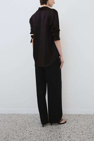 Back view of HERTH Tilde shirt and Zeno trousers in black organic silk — elegant sustainable fashion made in Italy, available at ASSOLUTO boutique.